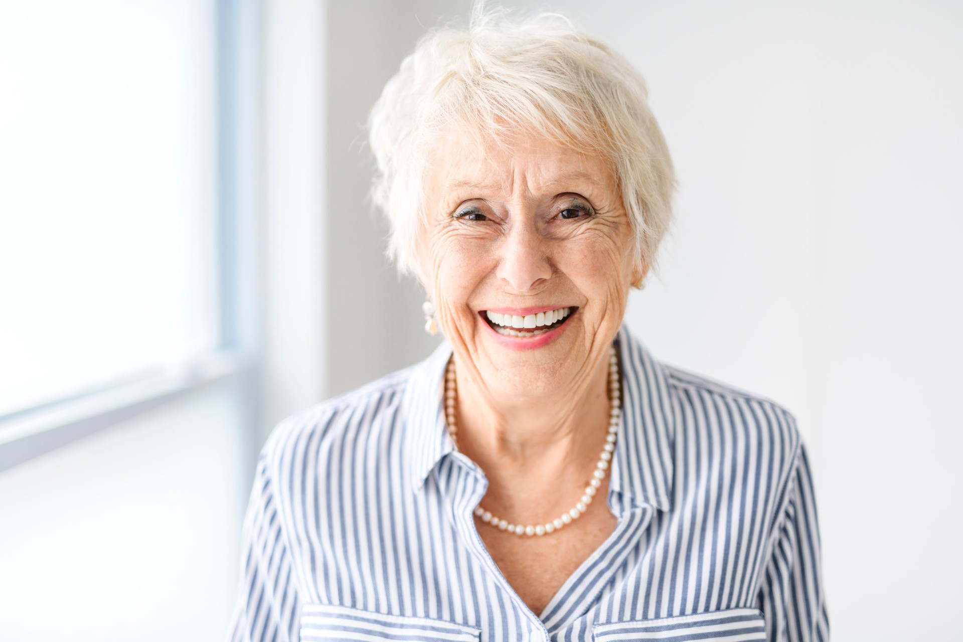 senior lady posing at home portrait close to a window